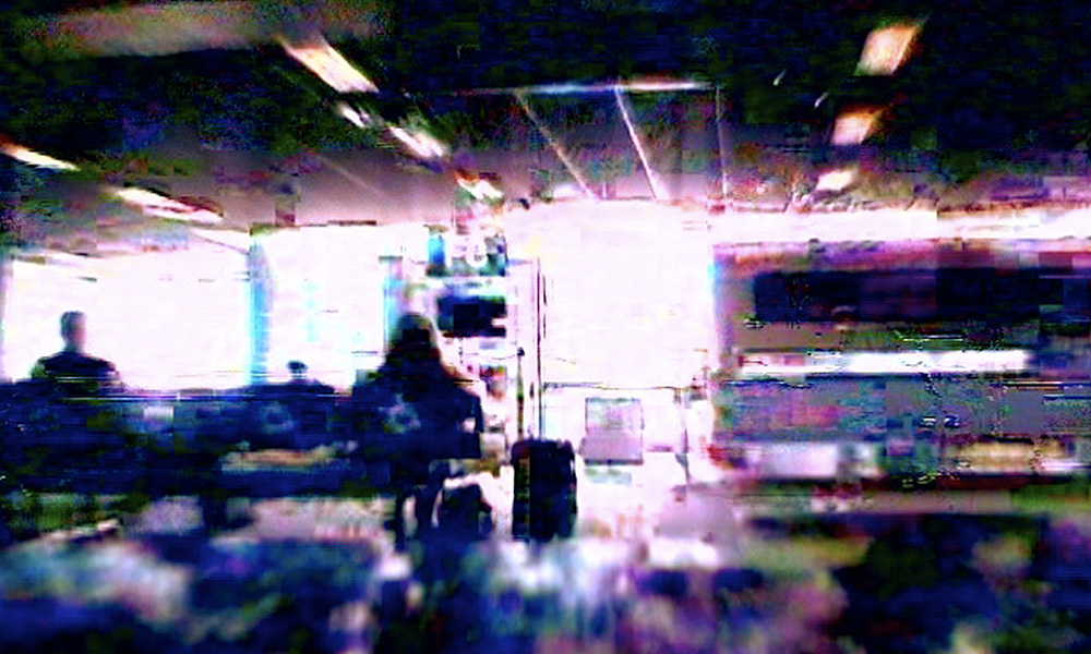 Glitchy images of people waiting in an airport.