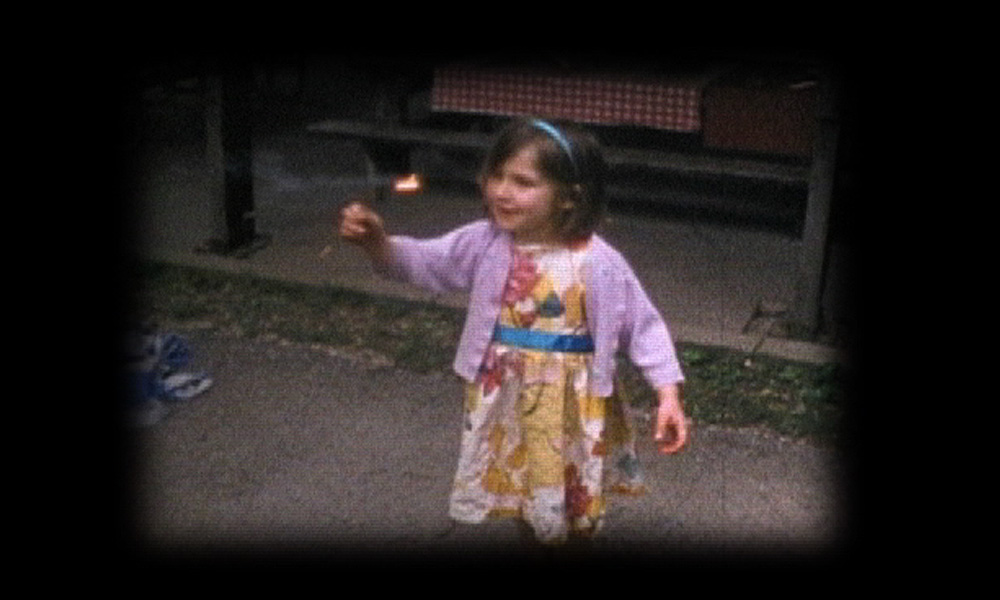 Home movie footage of a small girls with a sparkler.