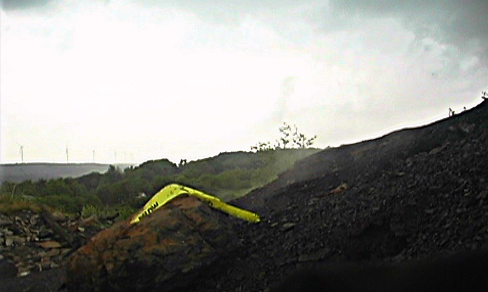 Caution tape over a smoking crater.