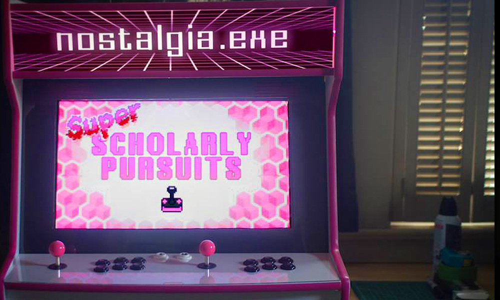A pink and black themed arcade cabinet that reads SUPER SCHOLARLY PERSUITS.